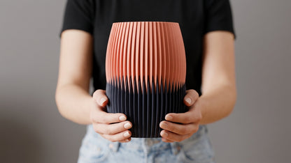 Interlock Vase in peach and charcoal held with both hands for scale.