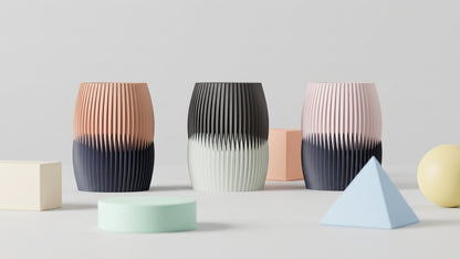 Three Interlock Vases in curated two-tone colorways styled with geometric objects.