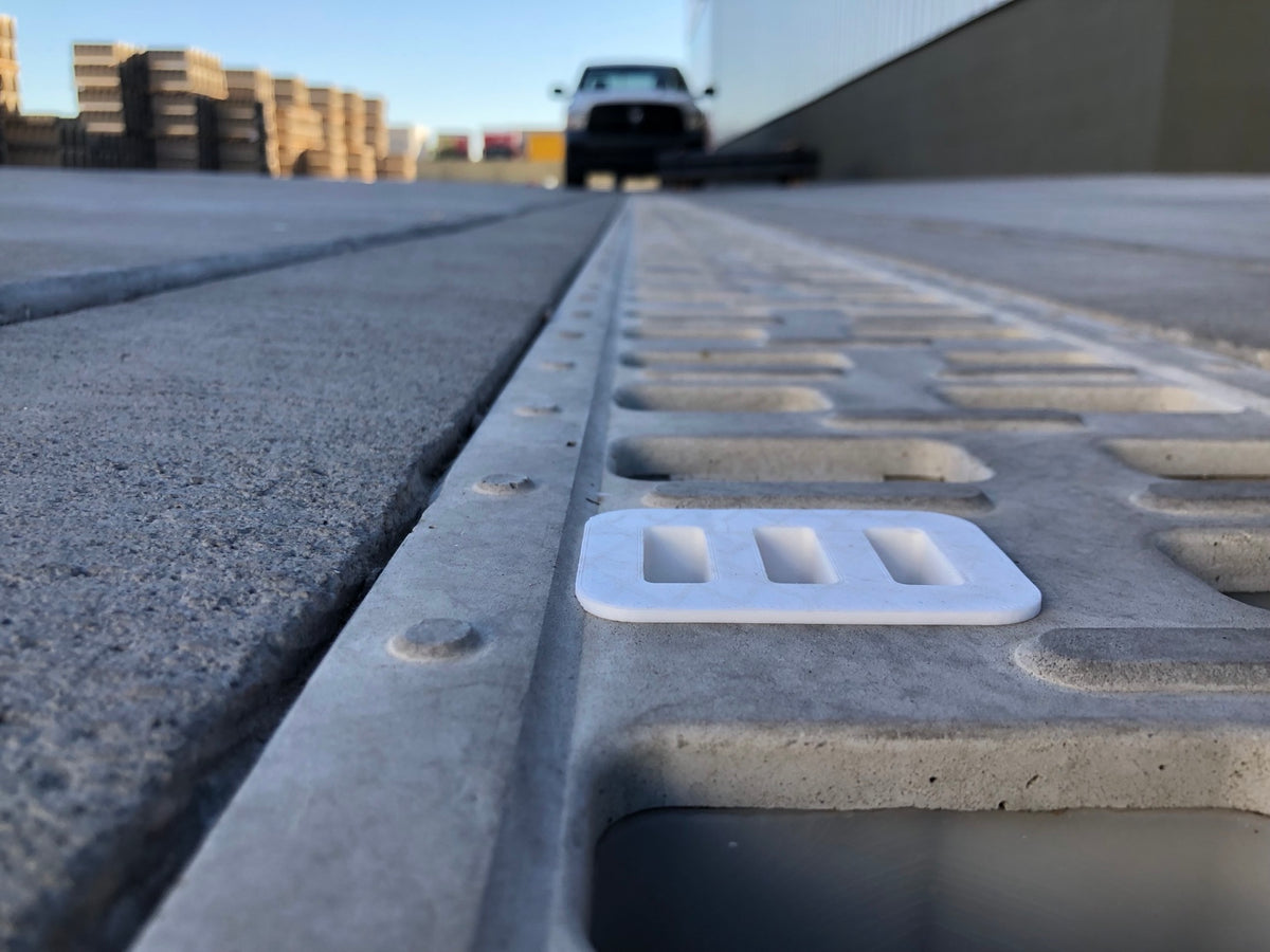 White 3D-printed inlet adapter positioned on a polymer-concrete trench drain.